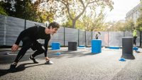 boy in black long sleeve shirt and blue pants playing with blue plastic bucket